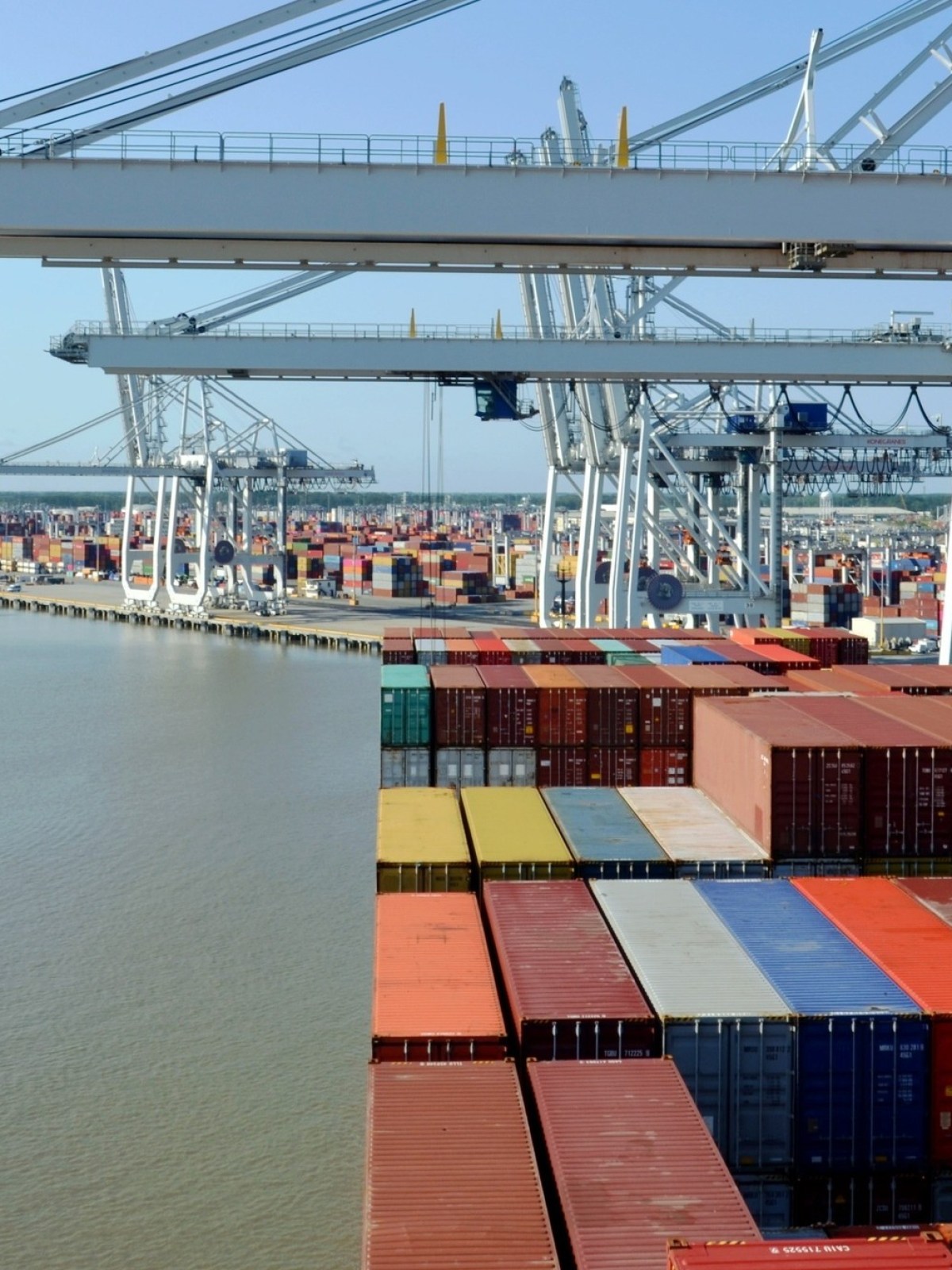a bunch of cargo containers next to a river