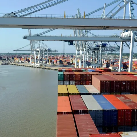 a bunch of cargo containers next to a river